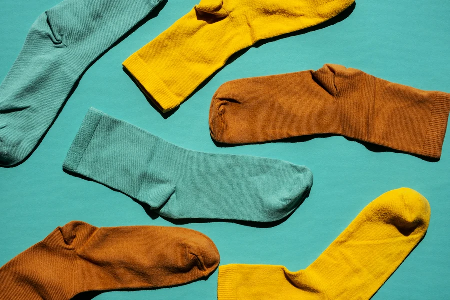 Teal, mustard and rust socks arranged on a turquoise background